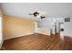 Open-concept living room with hardwood floors, a ceiling fan, and a blend of white and orange walls at 5630 N Rockingham Ln, McCordsville, IN 46055