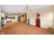 Open-concept living room with wood floors, multiple ceiling fans, and a view of the kitchen area at 5630 N Rockingham Ln, McCordsville, IN 46055
