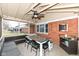 Relaxing covered patio with dining table, bench seating, and outdoor wicker furniture at 5924 Elaine St, Indianapolis, IN 46224