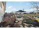Backyard patio with pond view, featuring a fire pit, comfortable seating, and an umbrella for shade at 5955 Stroup Dr, Noblesville, IN 46062
