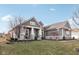 Stylish gray home shows manicured lawn with stone accents and features a welcoming covered front porch at 5955 Stroup Dr, Noblesville, IN 46062