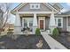 Inviting front porch with stone pillars, seating, and manicured landscaping create a welcoming entrance at 5955 Stroup Dr, Noblesville, IN 46062