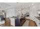 Modern kitchen boasts a large island with stone accents, granite countertops, and stainless steel appliances at 5955 Stroup Dr, Noblesville, IN 46062
