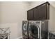 Convenient laundry room featuring a front load washer and dryer plus dark cabinetry at 5955 Stroup Dr, Noblesville, IN 46062