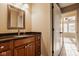 Bathroom featuring wood cabinets, granite countertop, stylish faucet and a decorative mirror at 6640 E Deerfield Dr, Zionsville, IN 46077