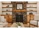 Close up of stone fireplace, built-in shelving, and hardwood floors at 6640 E Deerfield Dr, Zionsville, IN 46077