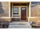 Charming front entry of a home with a wood door and brick accents at 6640 E Deerfield Dr, Zionsville, IN 46077