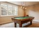 Spacious game room with a pool table, modern lighting and a large window at 6640 E Deerfield Dr, Zionsville, IN 46077