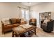 Inviting living room boasts a leather sofa, upholstered chairs, ottoman, and natural light from the window at 6640 E Deerfield Dr, Zionsville, IN 46077