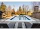 Outdoor swimming pool with lounge chairs, a brick fireplace, and privacy fence at 6640 E Deerfield Dr, Zionsville, IN 46077