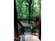 View from the stairs of a backyard with a fire pit and chairs in the woods at 6688 Bellsville Pike, Columbus, IN 47201
