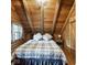 Bedroom with wooden-beamed ceiling, a bed with plaid bedding, and a window with curtains at 6688 Bellsville Pike, Columbus, IN 47201