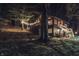 A gorgeous night view of a two-story log cabin home lit with string lights at 6688 Bellsville Pike, Columbus, IN 47201