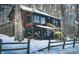 Rustic log cabin exterior showcasing a fenced in yard covered in winter snow at 6688 Bellsville Pike, Columbus, IN 47201
