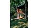 Exterior view of wooded property with hammock, stairs to log cabin and lawn at 6688 Bellsville Pike, Columbus, IN 47201