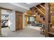 Carpeted living area with wood-paneled walls, comfortable seating, and staircase with wood steps at 6688 Bellsville Pike, Columbus, IN 47201