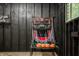 Basement basketball game area with black wood paneling, neon sign, and natural lighting from window at 7116 Grandview Rd, Columbus, IN 47201