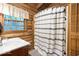Bathroom featuring log walls, a white vanity, and shower with patterned curtain at 7116 Grandview Rd, Columbus, IN 47201