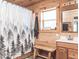 Charming bathroom featuring wood accents, a forest-themed shower curtain, and a rustic wooden bench at 7116 Grandview Rd, Columbus, IN 47201