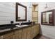 Bathroom featuring a framed mirror, granite countertop, and cabinet storage at 7116 Grandview Rd, Columbus, IN 47201