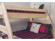 Close-up of bunk beds with a wooden frame, red plaid bedding and bear-themed pillows in a bedroom at 7116 Grandview Rd, Columbus, IN 47201