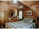 Cozy bedroom featuring wood paneling, a plaid bedspread, light fixture and natural light from the window at 7116 Grandview Rd, Columbus, IN 47201
