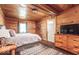 Relaxing bedroom with wood paneled walls and ceiling, dresser, comfortable queen bed and accent rug at 7116 Grandview Rd, Columbus, IN 47201