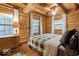 Inviting bedroom with log walls, natural light, and comfortable bedding at 7116 Grandview Rd, Columbus, IN 47201