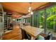 Open dining area with wood ceiling, hardwood floors, and large windows overlooking a private setting at 7116 Grandview Rd, Columbus, IN 47201