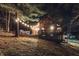 Charming log cabin with string lights and an inviting outdoor deck, perfect for evening relaxation at 7116 Grandview Rd, Columbus, IN 47201