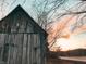 Rustic cabin exterior with weathered wood siding set against a colorful sunset sky in a rural setting at 7116 Grandview Rd, Columbus, IN 47201