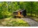 Charming home with a wooden deck surrounded by lush green trees at 7116 Grandview Rd, Columbus, IN 47201