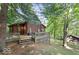Charming log cabin exterior with a spacious deck and an outdoor basketball court in a wooded setting at 7116 Grandview Rd, Columbus, IN 47201