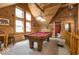 Relaxing game room featuring pool table, bright windows, wood paneled walls and attached bath at 7116 Grandview Rd, Columbus, IN 47201
