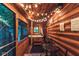 Rustic screened-in porch with a hot tub, string lights, and wooden finishes for a relaxing retreat at 7116 Grandview Rd, Columbus, IN 47201