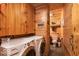 Functional laundry area with modern appliances and wood-paneled storage leading to a full bathroom at 7116 Grandview Rd, Columbus, IN 47201