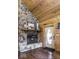 Cozy living room features a stone fireplace, wood paneled walls and ceilings, and a welcoming front door at 7116 Grandview Rd, Columbus, IN 47201