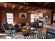 Rustic living area showcasing log walls, comfortable seating, and a geometric patterned rug at 7116 Grandview Rd, Columbus, IN 47201