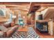 Inviting living room features log walls, plush seating, and a cozy fireplace at 7116 Grandview Rd, Columbus, IN 47201