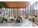Covered outdoor patio seating area with furniture and views of the surrounding forest at 7116 Grandview Rd, Columbus, IN 47201