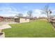 View of the backyard featuring a detached garage and lush green lawn at 714 S 4Th Ave, Beech Grove, IN 46107