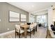 Stylish dining room boasts wood table, seating for six, modern art, and seamless flow into the adjacent living space at 7346 Shroyer Way, Noblesville, IN 46062