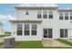 Back exterior view of a modern home with large windows, a patio, and a well-maintained lawn at 7346 Shroyer Way, Noblesville, IN 46062