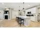 Open-concept kitchen with white cabinets, stainless steel appliances, and a view of the fireplace at 7346 Shroyer Way, Noblesville, IN 46062
