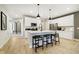 Bright kitchen with white cabinets, stainless steel appliances, center island with barstool seating, and wood floors at 7346 Shroyer Way, Noblesville, IN 46062