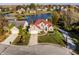 Aerial view of a brick home with a red tile roof, a manicured lawn, and a driveway at 7370 Chestnut Hills Blvd, Indianapolis, IN 46278