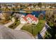 Aerial view of a brick home with a red tile roof, a well-manicured lawn, and waterfront access at 7370 Chestnut Hills Blvd, Indianapolis, IN 46278
