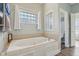 Bathroom with soaking tub, glass block window, and a doorway to the toilet at 7370 Chestnut Hills Blvd, Indianapolis, IN 46278