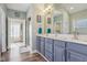 Bathroom featuring a double vanity, large mirror, and a glass block window at 7370 Chestnut Hills Blvd, Indianapolis, IN 46278