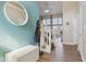 Inviting foyer with a staircase, a white storage bench, and a round mirror on the teal wall at 7370 Chestnut Hills Blvd, Indianapolis, IN 46278